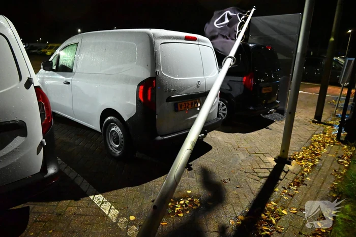 Vlaggenmast belandt op auto door sterke wind