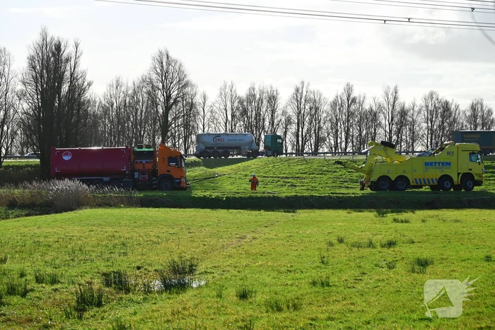 Vrachtwagen komt vast te zitten in weiland