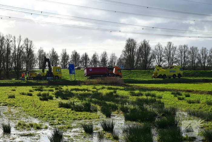 Vrachtwagen komt vast te zitten in weiland