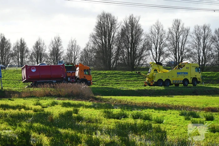 Vrachtwagen komt vast te zitten in weiland