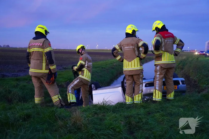 Brandweer haalt persoon uit auto in sloot