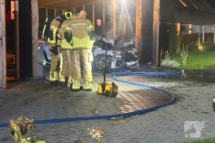 Auto vliegt in brand onder carport