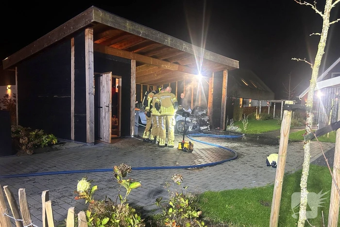 Auto vliegt in brand onder carport