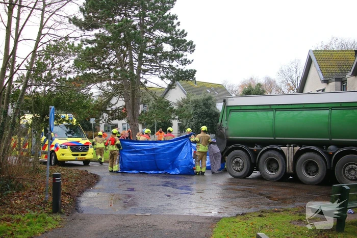 Persoon onder vrachtwagen