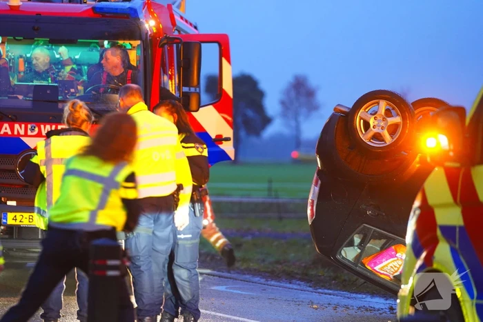 Auto op de kop na botsing met trekker en boom