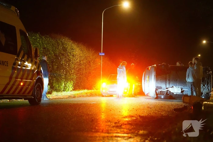 Auto botst tegen lantaarnpaal en belandt op zijkant