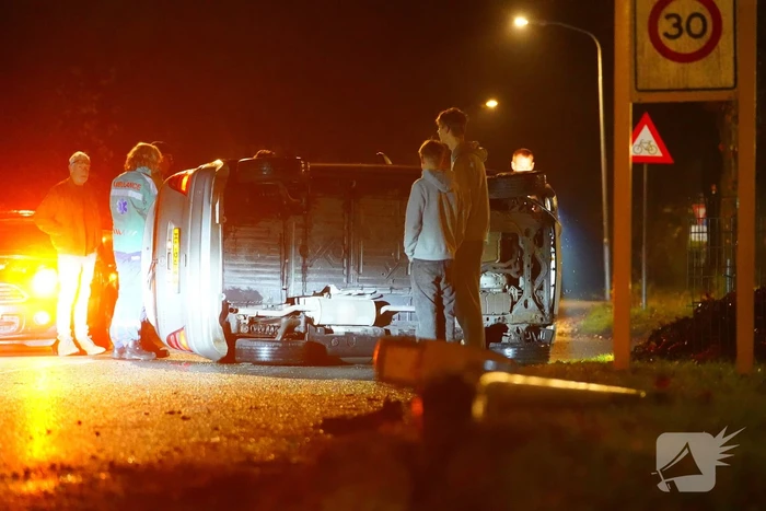Auto botst tegen lantaarnpaal en belandt op zijkant