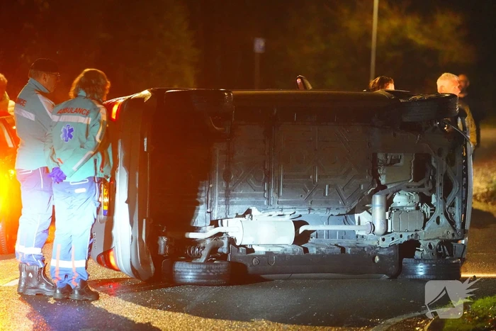 Auto botst tegen lantaarnpaal en belandt op zijkant