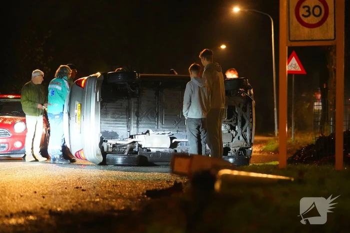 Auto botst tegen lantaarnpaal en belandt op zijkant