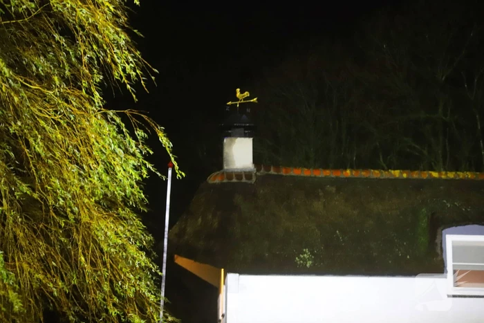 Brand in schoorsteen van woning met rieten kap