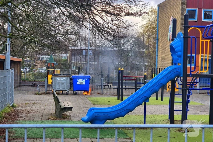 Papiercontainer op schoolplein in brand