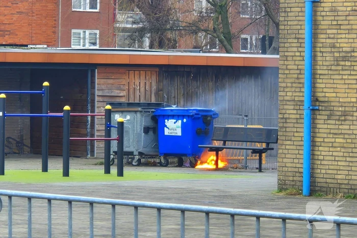 Papiercontainer op schoolplein in brand