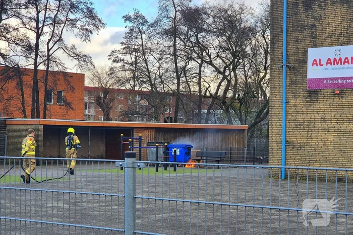 Papiercontainer op schoolplein in brand