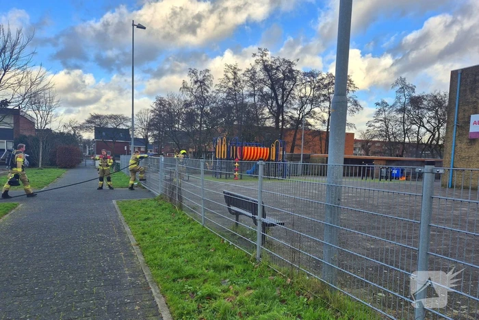 Papiercontainer op schoolplein in brand
