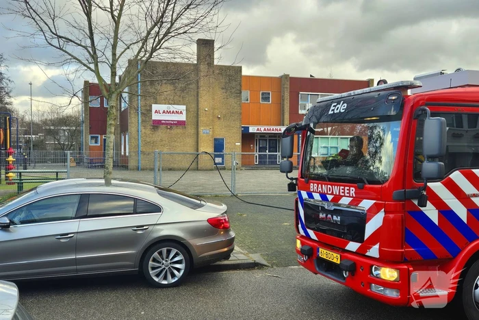 Papiercontainer op schoolplein in brand