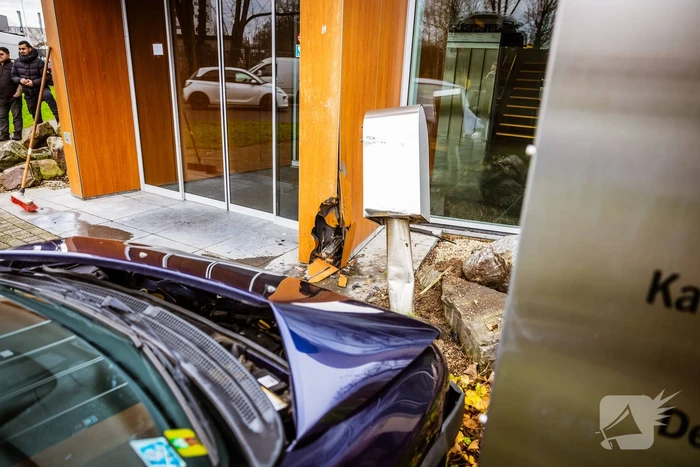 Auto komt tegen bedrijfspand tot stilstand na botsing