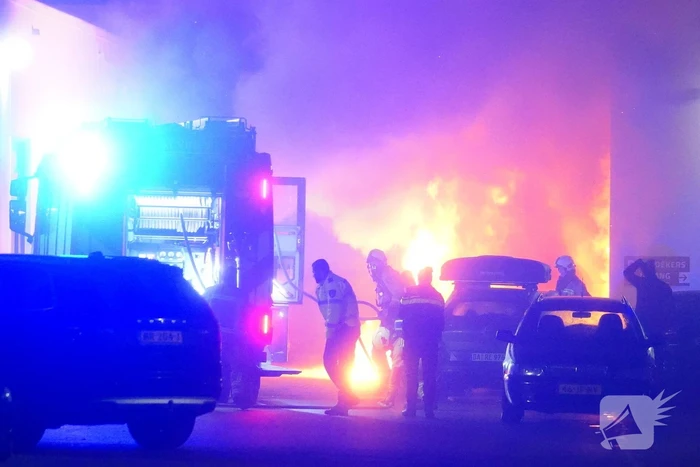 Uitslaande autobrand slaat over naar loods