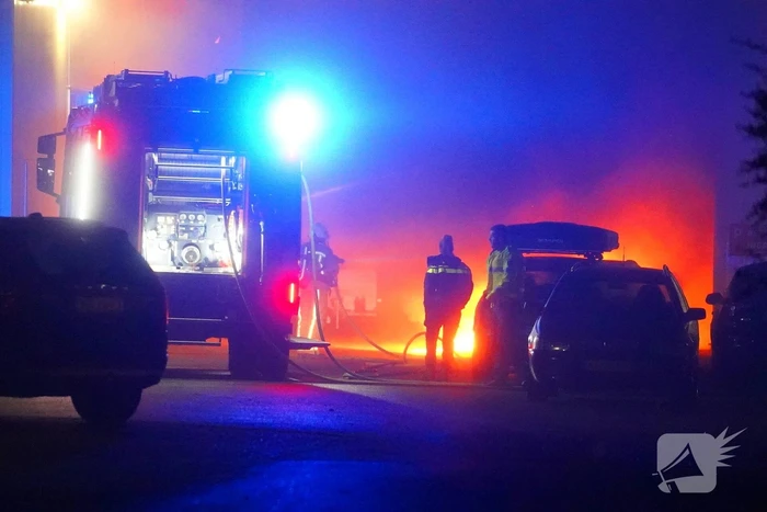 Uitslaande autobrand slaat over naar loods