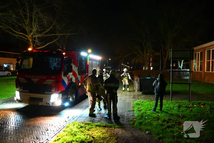 Brandweer blust brand in vuilcontainer