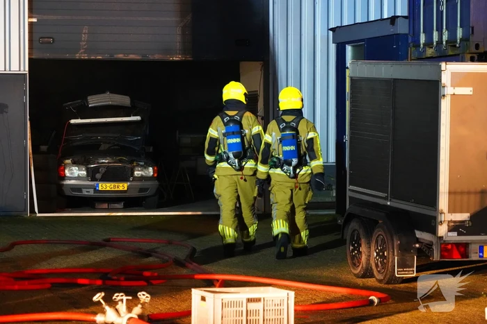 Voertuig vliegt in brand in garagebedrijf