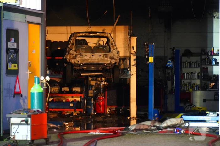 Voertuig vliegt in brand in garagebedrijf