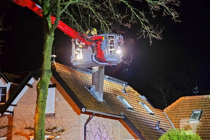Brandweer blust brand in schoorsteen