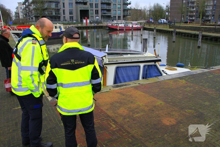 Boot verdwijnt onder water in haven, berging trekt veel bekijks