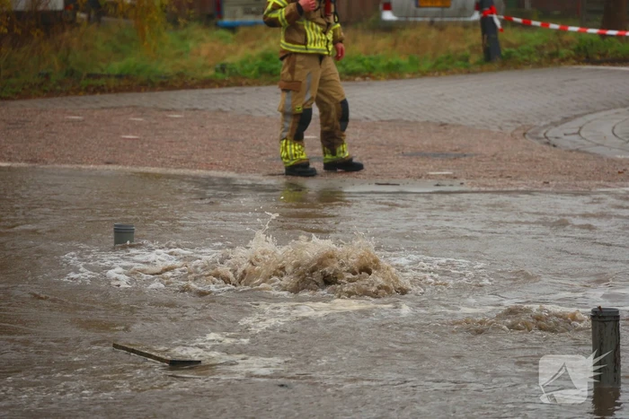 Straat onder water gelopen door kapotte waterleiding