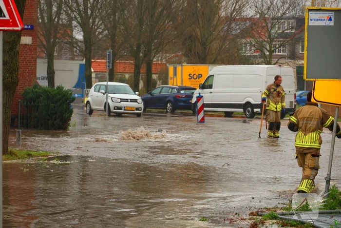 Straat onder water gelopen door kapotte waterleiding