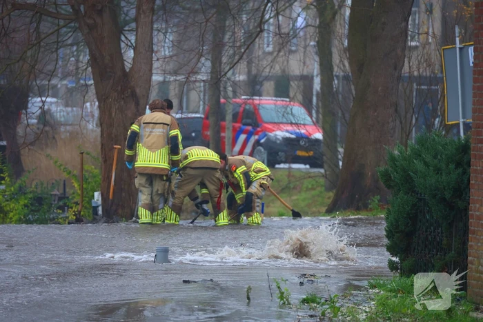Straat onder water gelopen door kapotte waterleiding