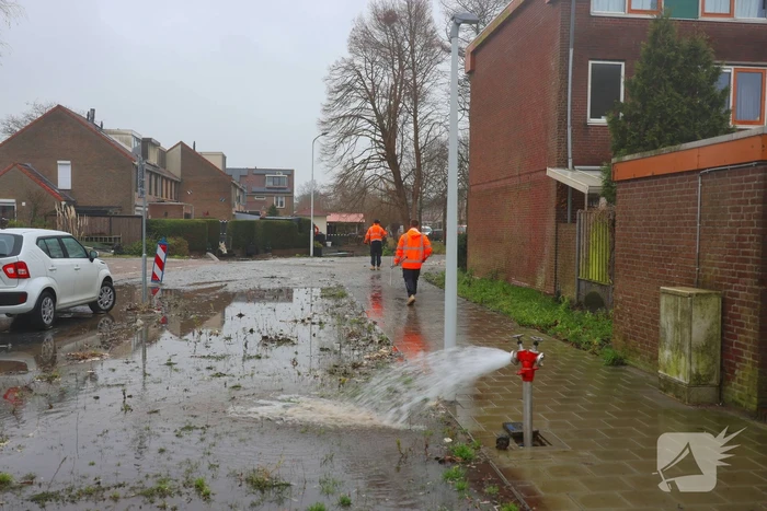 Straat onder water gelopen door kapotte waterleiding