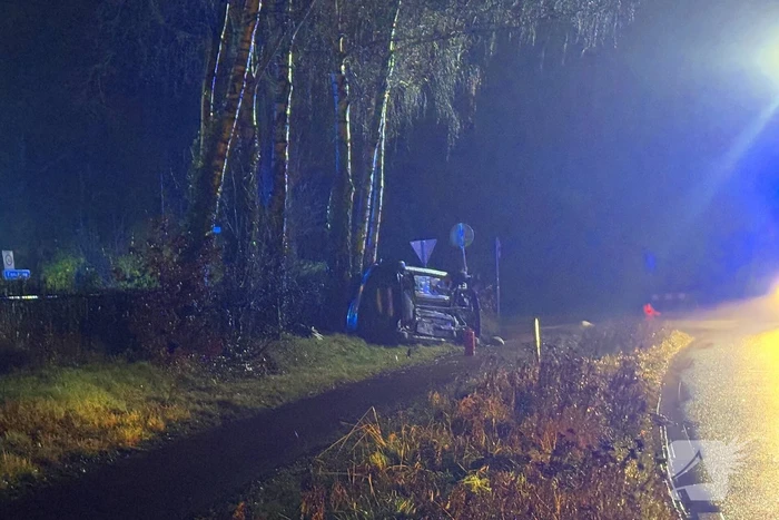 Auto vliegt uit de bocht en belandt op zijkant