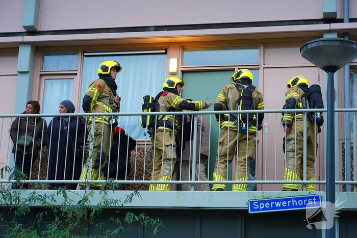 Bewoner reageert geschrokken na brand onder trap van flat