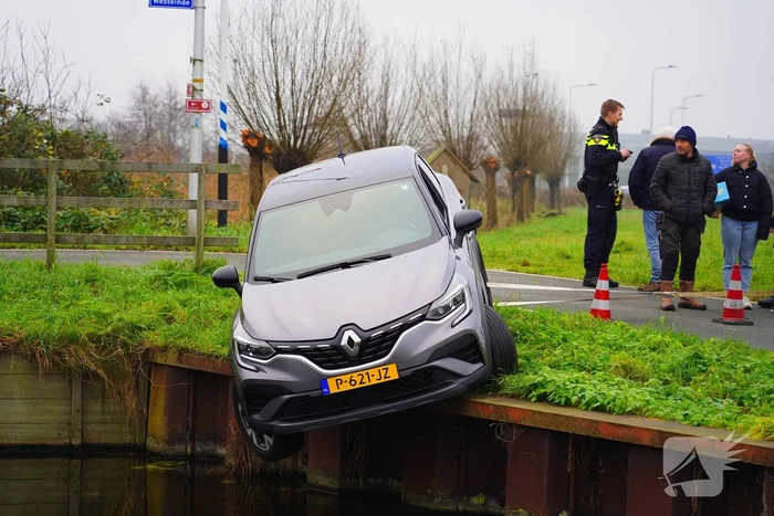 Auto komt boven water te hangen bij keeractie op fietspad