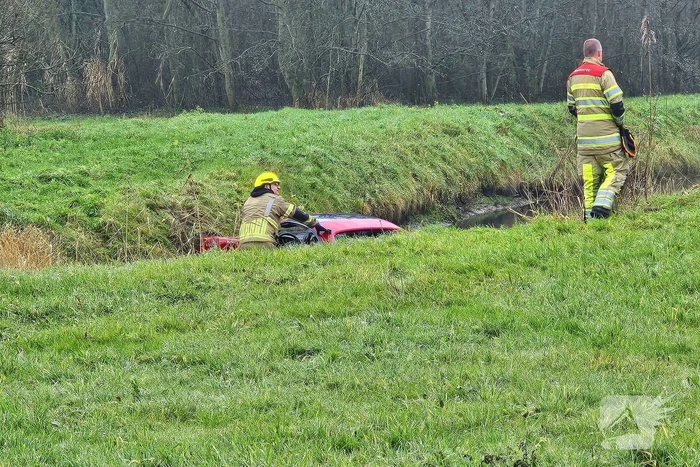 Auto vliegt uit de bocht van snelweg en belandt in water, inzittende gewond