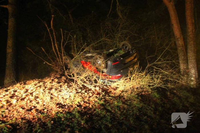 Auto vliegt uit beruchte bocht en belandt op de kop