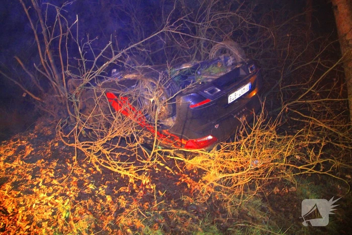 Auto vliegt uit beruchte bocht en belandt op de kop