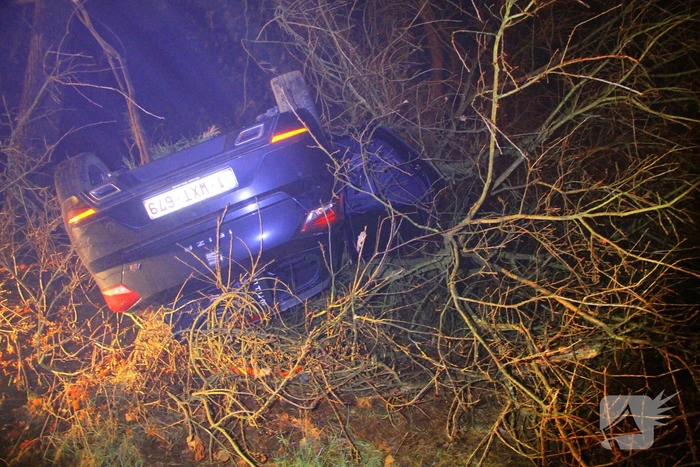 Auto vliegt uit beruchte bocht en belandt op de kop