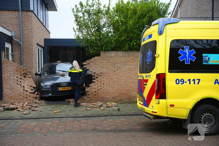 Auto rijdt dwars door tuinmuur