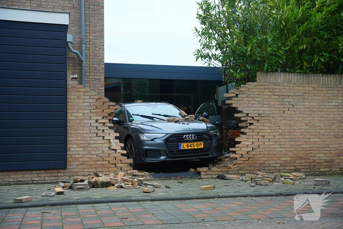 Auto rijdt dwars door tuinmuur