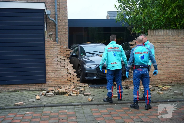 Auto rijdt dwars door tuinmuur