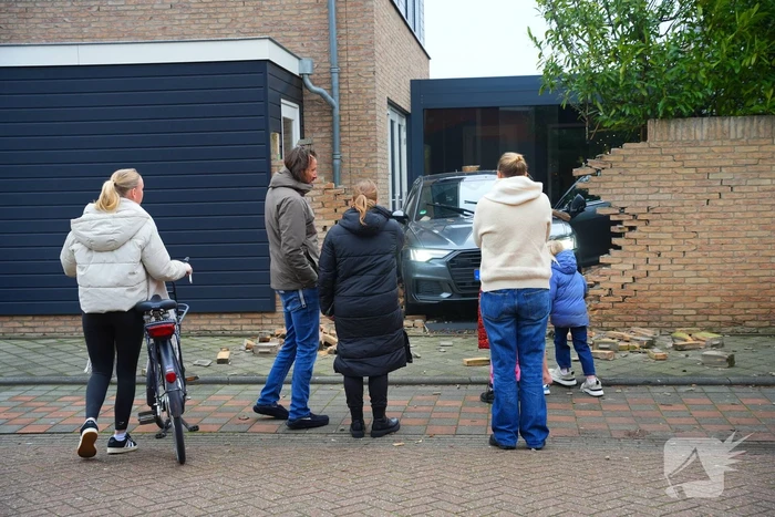 Auto rijdt dwars door tuinmuur