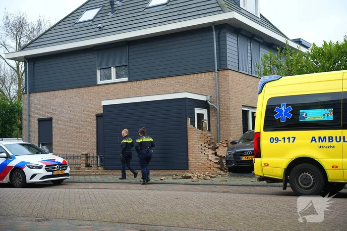 Auto rijdt dwars door tuinmuur