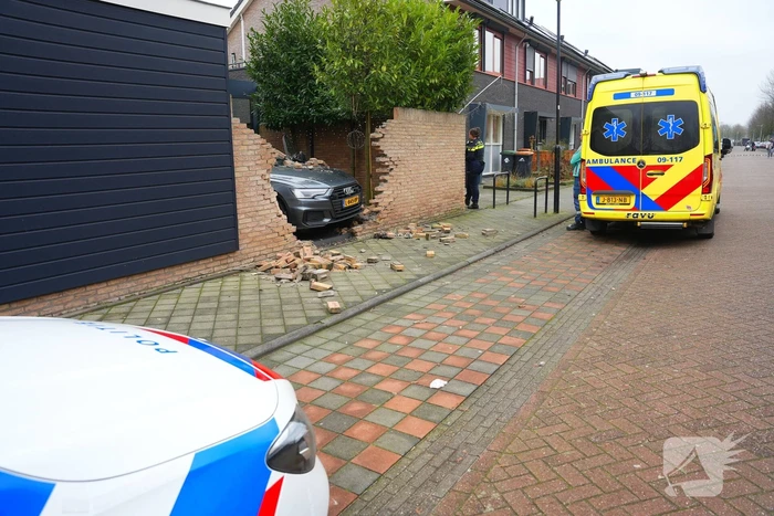 Auto rijdt dwars door tuinmuur
