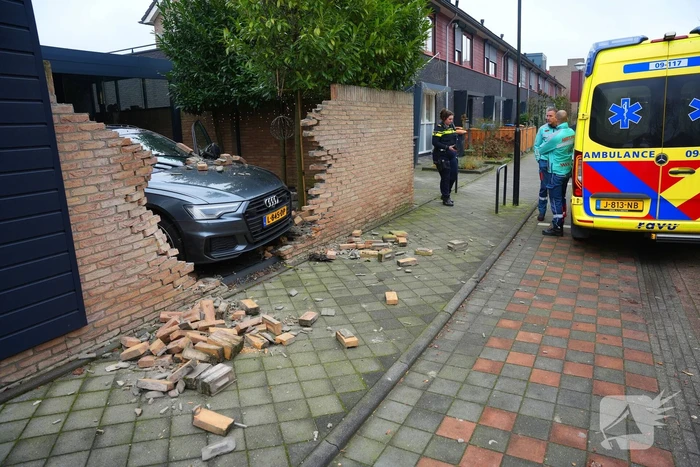 Auto rijdt dwars door tuinmuur
