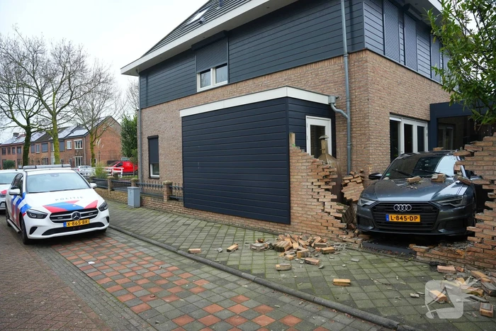 Auto rijdt dwars door tuinmuur