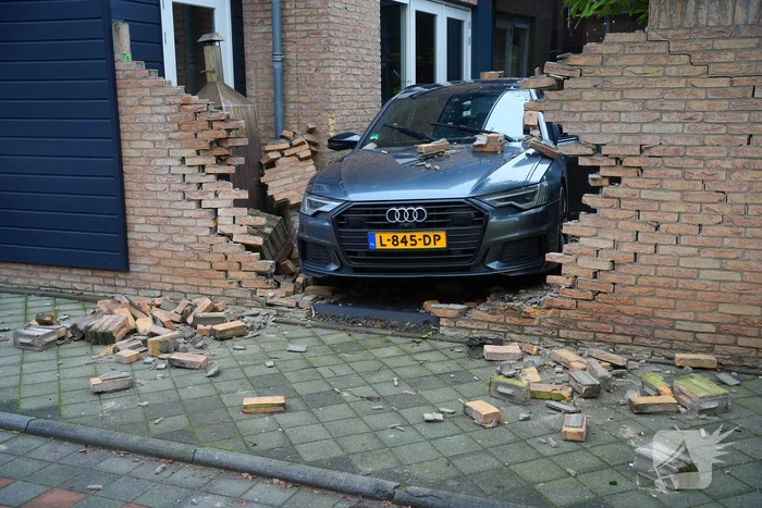 Auto rijdt dwars door tuinmuur