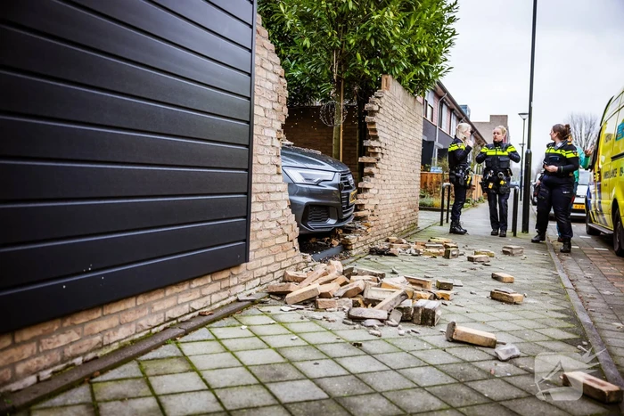 Auto rijdt dwars door tuinmuur