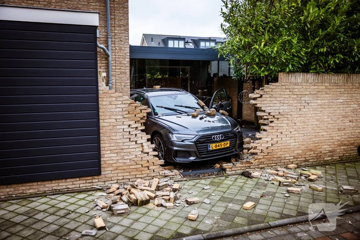Auto rijdt dwars door tuinmuur
