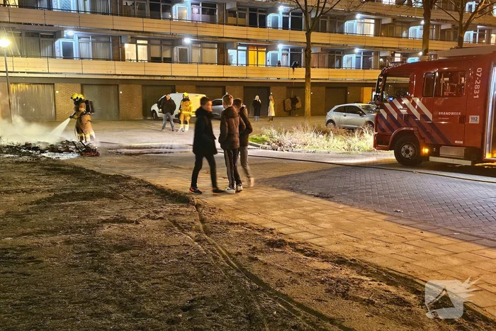 Brandweer blust brandende berg afval